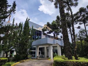 a building with trees in front of it at Flat Luxo 3010 com banheira Mountain Village Laje de Pedra Canela in Canela