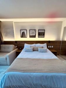 ein Schlafzimmer mit einem großen Bett mit drei Bildern an der Wand in der Unterkunft Flat em Itaipava! in Araras Petropolis