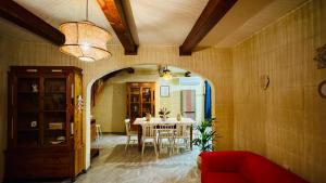 a dining room with a table and a red couch at See You Mystic Flowers & Private Pool in Għarb