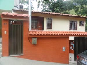 a small orange and white building with a window at Casa Serra Macaé in Água Boa