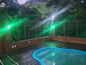 a hot tub on a deck with lights on a fence at Casa Serra Macaé in Água Boa