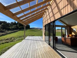 eine Holzterrasse mit Blick auf ein Haus in der Unterkunft Manawa - Ohakune Holiday Home in Ohakune