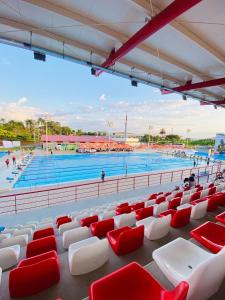 a view of a swimming pool with red and white chairs at La vida es bella apto central cerca al aeropuerto con hamaca in Pereira