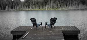 zwei Stühle auf einem Steg im Wasser in der Unterkunft Bear Lake Cottage in Mountain Grove + 6 Fotos