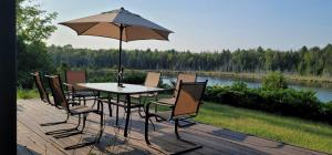 ein Tisch und Stühle mit einem Sonnenschirm auf einem Deck in der Unterkunft Bear Lake Cottage in Mountain Grove