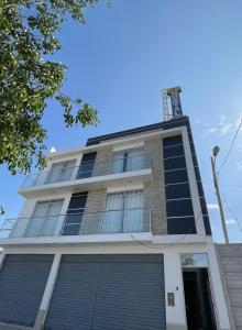 a tall building with blue windows on top of it at Hostal los Ficus in Ica