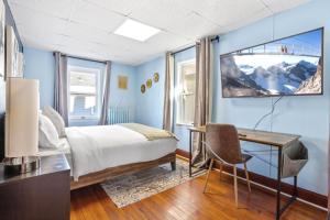 ein Schlafzimmer mit einem Bett, einem Schreibtisch und einem Fernseher in der Unterkunft 8BR 3BA Classic by Tropicana, Boardwalk, Beach in Atlantic City