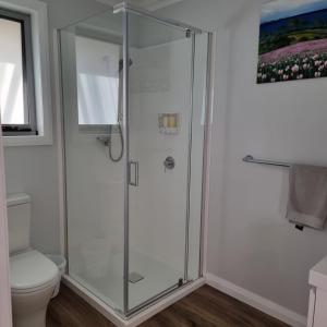 a shower stall in a bathroom with a toilet at Kadi House - Unit 1 in Wynyard