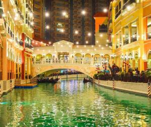 un pont sur une rivière dans une ville la nuit dans l'établissement BGC Mckinley City Center Apartments - Global City, à Manille