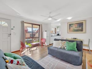ein Wohnzimmer mit Sofa und Tisch in der Unterkunft Tranquil 2-Bed Townhouse Close to Redcliffe Beach in Redcliffe
