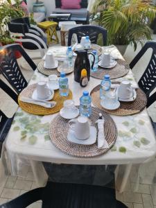 a white table with plates and dishes on it at Villa soleil du Sénégal in Dakar