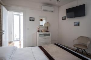 a white bedroom with a bed and a chair at La Giulietta in Tortorella