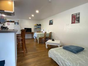 a room with two beds and a kitchen and a table at Gîte du cerisier in Raddon-et-Chapendu