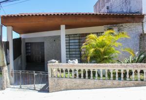 una casa con balcón con portón y palmeras en hostel Rep MADAGASCAR, en Florianópolis