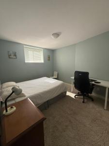 a bedroom with a bed and a desk and a chair at 2 bedroom Suite with private entrance in Langley
