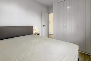 a bedroom with a large white bed in it at Rietpanne 0106 in Koksijde