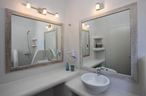 a bathroom with two mirrors and a sink at Porto Raphael Residences & Suites in Agios Ioannis