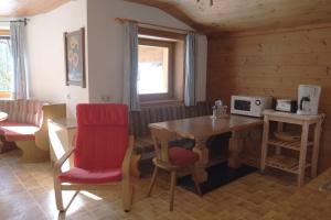 a room with a table and a chair and a microwave at Ferienwohnung Achten in Waidring