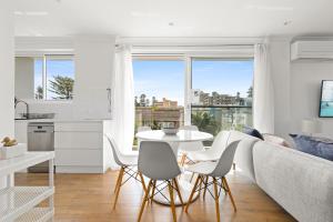 a living room with a couch and a table and chairs at Coastal 2-Bed Apartment Steps from Manly Beach in Sydney