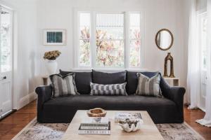 a living room with a black couch and a table at Luxe Hinterland Stay, Eastnor at Montville Estate in Montville