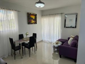 a living room with a purple couch and a table at Hermoso Apartamento en 3er nivel con terraza privada in Bonao +22 photos