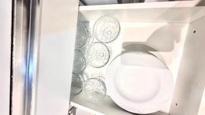 a white toilet in a white cabinet with plates at Seminate Apartamento in Franca +12 photos