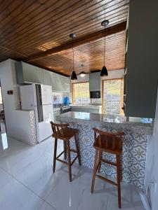 a kitchen with two chairs and a counter top at Rancho do Léo in Conceição do Mato Dentro +12 photos
