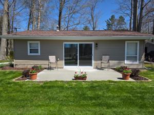 霍顿湖Elaine’s Lighthouse的一间有两把椅子的房子和一个长满绿草的门廊