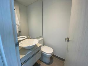 a white bathroom with a sink and a toilet at Exclusivo Apartamento en Distrito 90 in Barranquilla +17 photos