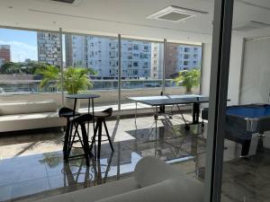 a living room with two tables and a large window at Exclusivo Apartamento en Distrito 90 in Barranquilla