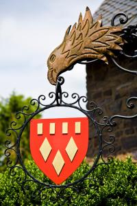 um sinal com um dragão em cima de uma cerca em Hotel Burg Arras em Alf