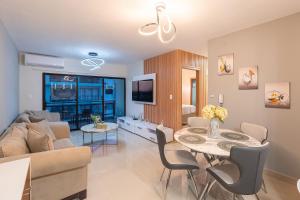 ein Wohnzimmer mit einer Couch und einem Tisch mit Stühlen in der Unterkunft Epic Paraíso Elegance and Comfort in Punta Cana