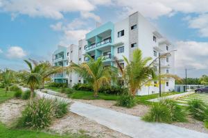 ein weißes Gebäude mit Palmen davor in der Unterkunft Epic Paraíso Elegance and Comfort in Punta Cana