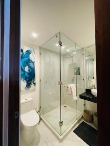 a bathroom with a glass shower with a toilet and a sink at Oxygen! beautiful beach apartament 1BR Ocean view in Playa del Carmen