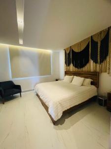 a bedroom with a large bed and a chair at Oxygen! beautiful beach apartament 1BR Ocean view in Playa del Carmen +33 photos