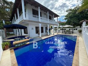 a villa with a swimming pool in front of a house at Casa Quinta Melgar in Melgar
