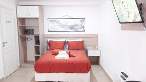 ein kleines Schlafzimmer mit einem roten Bett mit roten Kissen in der Unterkunft Refugio Sureño departamento completo centrico wifi in Ushuaia