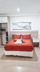 a bedroom with a large bed with red sheets at Refugio Sureño departamento completo centrico wifi in Ushuaia
