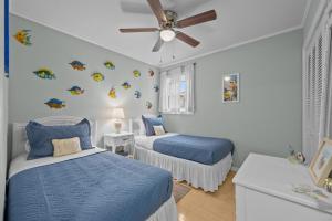 a bedroom with two beds and a ceiling fan at Sea La Vie- Oceanfront Family Retreat in North Topsail Beach +47 photos