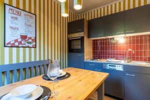 a kitchen with a wooden table and blue cabinets at Ferienwohnung mit Terrasse in St Peter-Ording Dorf – 1-Raum, EG, 45 m² in Ording +5 photos