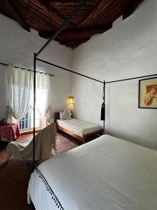 a bedroom with a bed and a bed and a chair at Behind js in Essaouira +15 photos