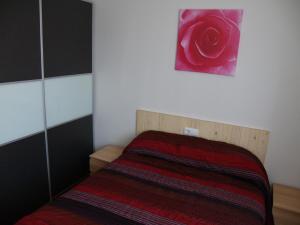 コカにあるApartamentos Las Casitas de El Blasónのベッドルーム1室(壁にバラのベッド1台付)