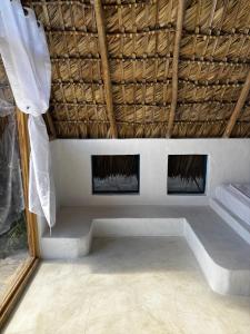 a room with a bed with a straw roof at Blue Beach Eco-Hotel by Sanfabini in Bayahibe +70 photos