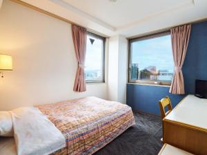 a hotel room with a bed and a desk and window at Hotel Fukui Castle - Vacation STAY 58692v in Fukui +62 photos