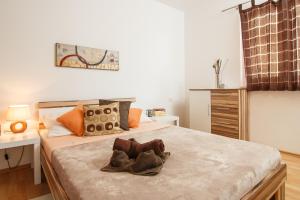 a bedroom with a bed with a pair of shoes on it at Apartments Villa Stari Koko in Omiš