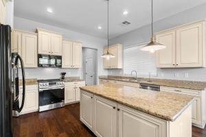 une cuisine avec des armoires blanches et des comptoirs en granit dans l'établissement King bed Pool Fire Pit Office, à Liberty