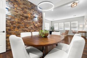 une salle à manger avec une table en bois et des chaises blanches dans l'établissement King bed Pool Fire Pit Office, à Liberty