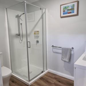 a shower with a glass door in a bathroom at Kadi House - Unit 2 in Wynyard