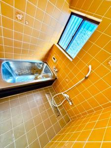 Un baño con lavabo y ventana. en なぎさの宿 日本文化古き良き建物畳敷 大家族グループ利用 長期滞在ok駐車場無料 日本の真ん中Mie Suzuka Ise, en Tsu