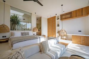 a bedroom with a king sized bed and a couch at Casa Noema in Kerobokan